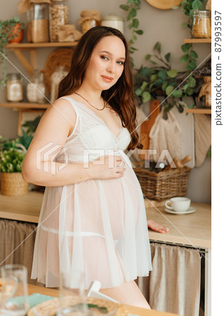 a pregnant woman in white peignoir. beautiful and sexy clothes for pregnant. a pregnant woman in white peignoir. beautiful and sexy clothes for pregnant. 87993597