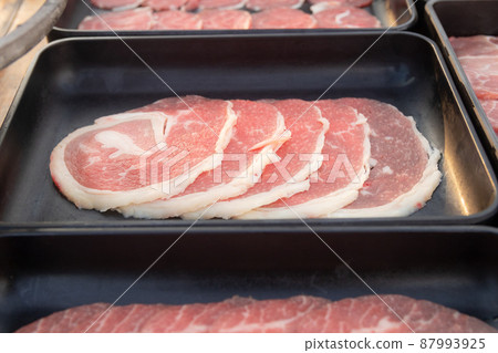 Raw sliced beef on black tray 87993925
