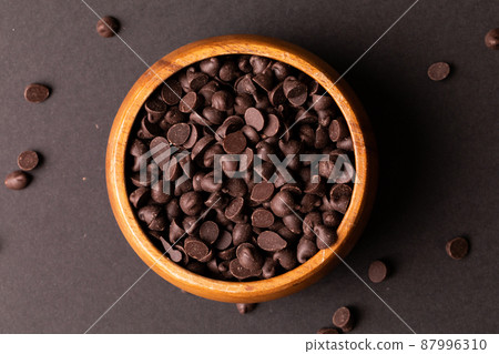 Directly above view of fresh chocolate chips in wooden bowl over colored background 87996310
