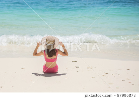 Woman tourist in pink swimsuit and hat, happy traveler sunbathing at Paradise beach on Islands. destination, wanderlust, Asia Travel, tropical summer, vacation and holiday concept Woman tourist in pink swimsuit and hat, happy traveler sunbathing at Paradise beach on Islands. destination, wanderlust, Asia Travel, tropical summer, vacation and holiday concept 87996878