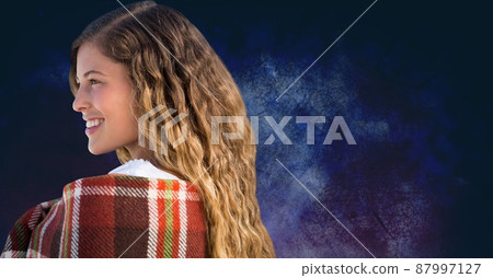 Side view of a caucasian woman smiling against copy space on textured blue background Side view of a caucasian woman smiling against copy space on textured blue background 87997127