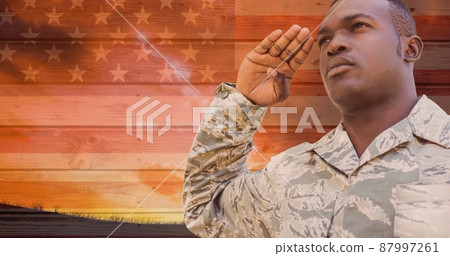 Digital composite image of young african american military man saluting against america flag 87997261