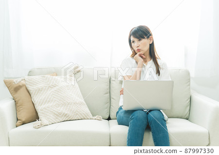 Middle-aged woman sitting on the sofa (in trouble) Middle-aged woman sitting on the sofa (in trouble) 87997330