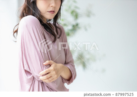 一個身體狀況不佳的女人,穿著她的房間衣服抱著她的身體 一個身體狀況不佳的女人,穿著她的房間衣服抱著她的身體 87997525