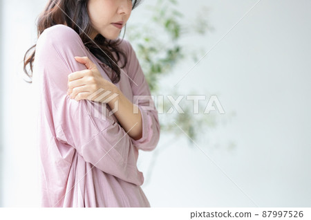A woman in poor physical condition holding her body in her room clothes 87997526