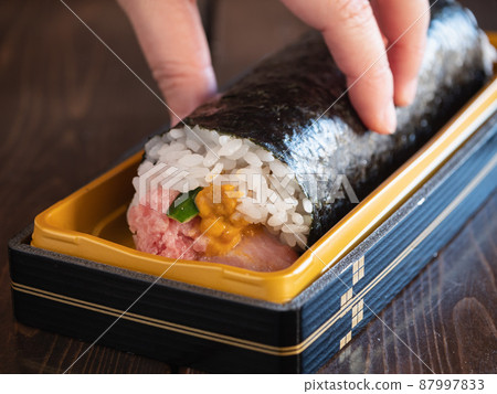 Seafood thick roll. A thick sushi roll with tuna, cucumber and sea urchin wrapped in vinegared rice. Seafood thick roll. A thick sushi roll with tuna, cucumber and sea urchin wrapped in vinegared rice. 87997833