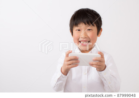 Boy playing on smartphone 87999048
