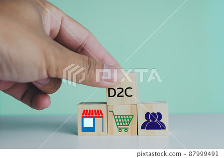 Hand put wooden cubes with Direct to Consumer D2C on table and copy space.Business concepts. Hand put wooden cubes with Direct to Consumer D2C on table and copy space.Business concepts. 87999491