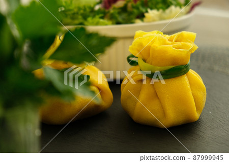 Pancakes. Yellow stuffed bliny with mushrooms and sour cream. Light background. Beautiful and delicious breakfast at home or in a cafe. Selective focus. Concept: Shrovetide menu. Slavic maslenitsu 87999945