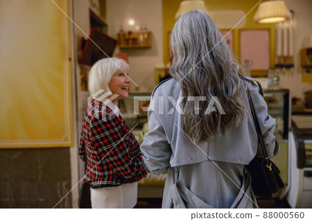 Happy female friends strolling down city center Happy female friends strolling down city center 88000560