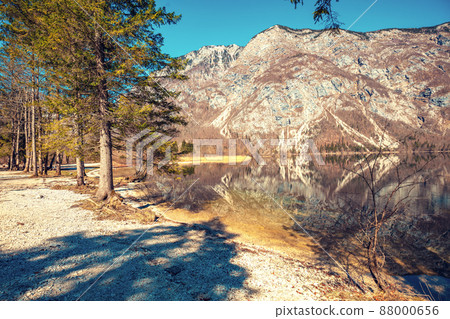 Rocky shore of the mountain lake. Beautiful nature. Reflection on the lake Rocky shore of the mountain lake. Beautiful nature. Reflection on the lake 88000656
