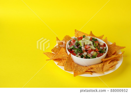 Pico de Gallo and chips on yellow background Pico de Gallo and chips on yellow background 88000932