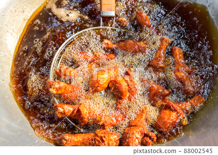Chef cooking crispy fried chicken in oil hot pan on street food market in Thailand. Chef cooking crispy fried chicken in oil hot pan on street food market in Thailand. 88002545