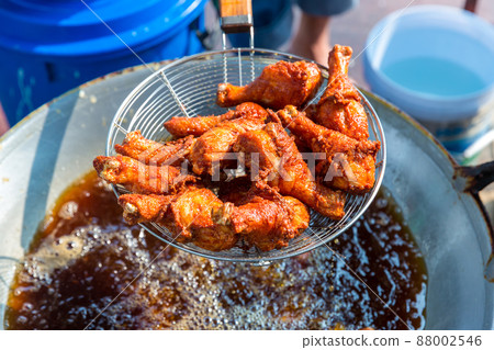 Chef cooking crispy fried chicken in oil hot pan on street food market in Thailand. 88002546