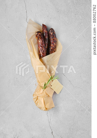 Overhead view of dried sausage made of venison spicy meat and lard in wrapping paper Overhead view of dried sausage made of venison spicy meat and lard in wrapping paper 88002762