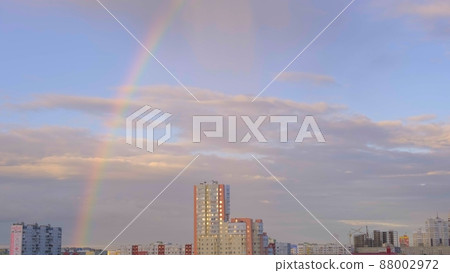 Multicolored rainbow and clouds in the sky after the rain and multi storey buildings in the city Multicolored rainbow and clouds in the sky after the rain and multi storey buildings in the city 88002972