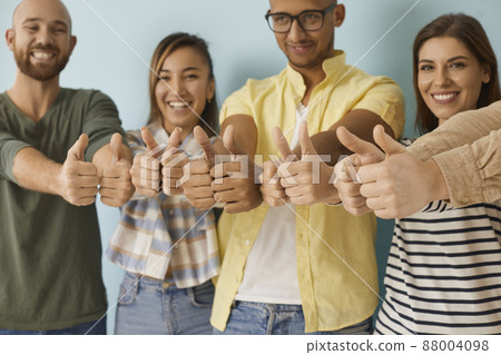 Diverse group of happy cheerful young people showing like gestures all together. Joyful optimistic multiethnic multicultural men and women giving thumbs up and smiling. Close up of human hands 88004098
