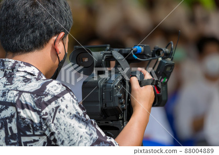 Video camera operator working with his equipment.  88004889