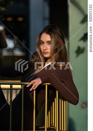 Portrait of a fashionable young brunette woman wearing solid long sleeve bodycon one piece jumpsuits 88005192