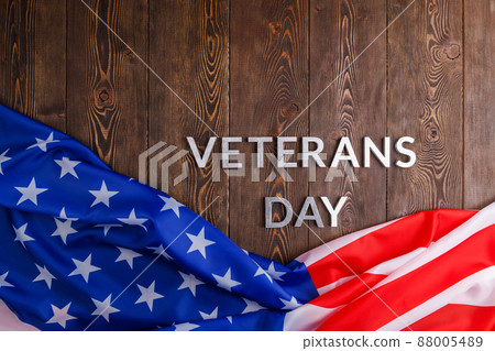 the words veterans day laid with silver metal letters on wooden board surface with crumpled usa flag 88005489