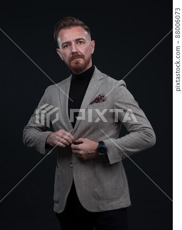 Portrait of a stylish elegant senior businessman with a beard and casual business clothes in photo studio isolated on dark background gesturing with hands 88006073