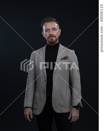 Portrait of a stylish elegant senior businessman with a beard and casual business clothes in photo studio isolated on dark background gesturing with hands 88006119
