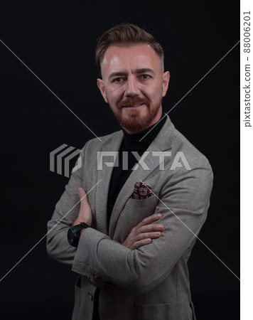 Portrait of a stylish elegant senior businessman with a beard and casual business clothes in photo studio isolated on dark background gesturing with hands 88006201
