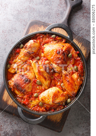 Mediterranean chicken baked with tomatoes, peppers, onions and garlic close-up in a frying pan. vertical top view 88006275