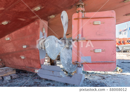 Metal propeller of ship on ground in old shipbuilding plant on coast 88008012