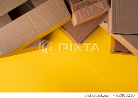Beige cardboard boxes on yellow background, close up 88008230