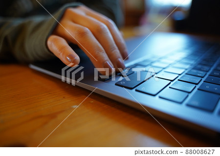 A woman working on a computer [hands only] 88008627