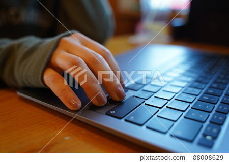 A woman working on a computer [hands only] 88008629