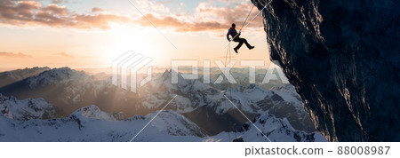 Adult adventurous man rappelling down a rocky cliff. Extreme adventure composite. Adult adventurous man rappelling down a rocky cliff. Extreme adventure composite. 88008987