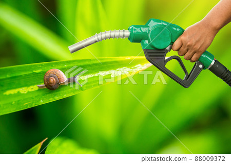 Green conservation. Gas pump nozzle and leaf background. 88009372