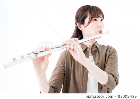 A woman playing the flute in a casual outfit A woman playing the flute in a casual outfit 88009459
