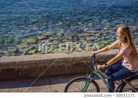 Woman tourist on a bicycle explores Budva in Montenegro. Cycling in Montenegro concept 88011175