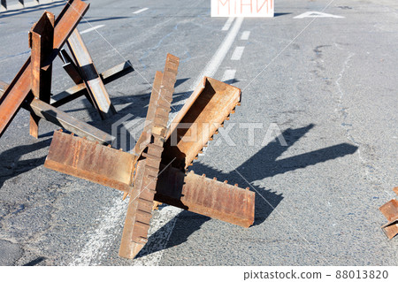 Metal welded hedgehogs on the carriageway of a city road on a sunny day. 88013820