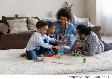 Happy parents teaching two son and daughter to construct 88014561