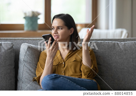 Young woman holding smart phone speaking on speakerphone 88014855