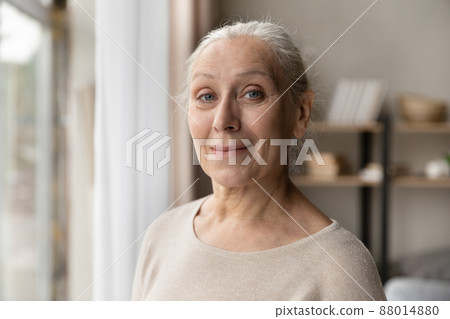 Headshot portrait attractive older woman posing indoor 88014880