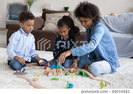 Positive mom and two kids playing with toy construction models 88014881