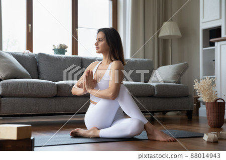 Young sporty woman perform Ardha Matsyendrasana practicing yoga at home 88014943