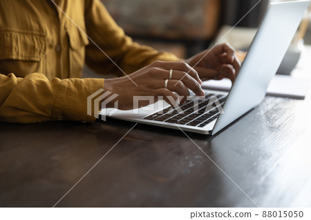 African female employee working at laptop, typing on keyboard African female employee working at laptop, typing on keyboard 88015050