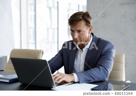 Focused 40s middle aged businessman working on computer. 88015164