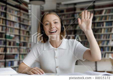 Smiling millennial female student in headphones holding video call. 88015172
