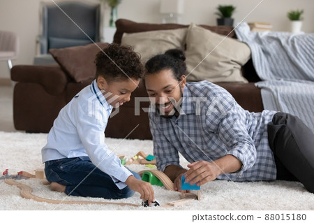 Cheerful dad and son boy playing toys on floor 88015180