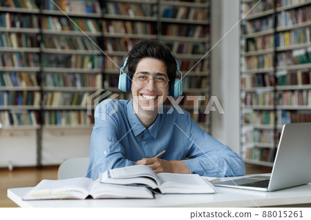 Smiling motivated millennial Jewish male student studying in library. Smiling motivated millennial Jewish male student studying in library. 88015261