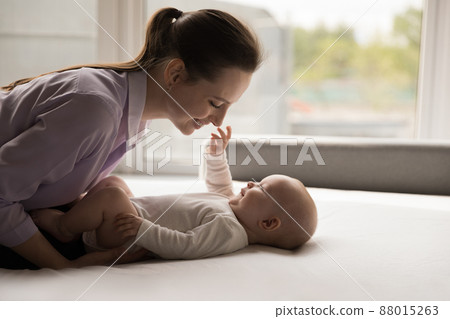 Happy new mother caressing, cuddling sweet baby Happy new mother caressing, cuddling sweet baby 88015263