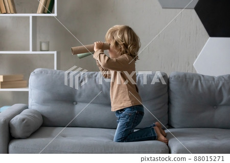 Happy adorable small boy playing alone at home. 88015271