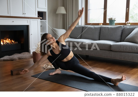 Young fit woman doing Side Lunge asana at home 88015322